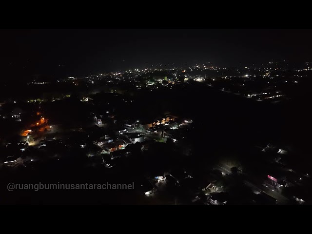 Drone DJI AIR 3S terbang di malam hari di pinggiran kota