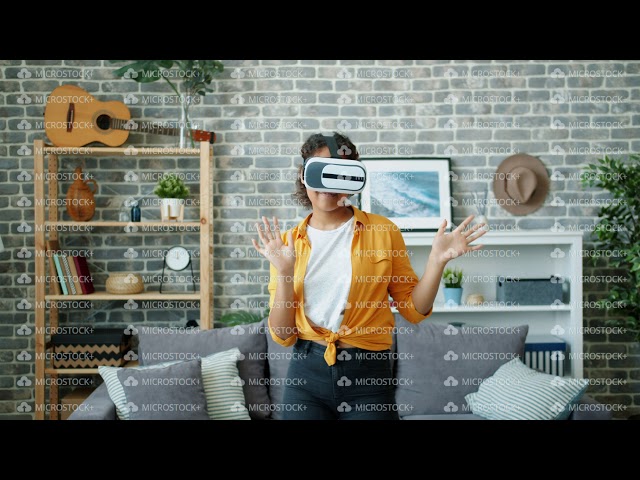 Happy African American woman dancing in virtual reality glasses at home